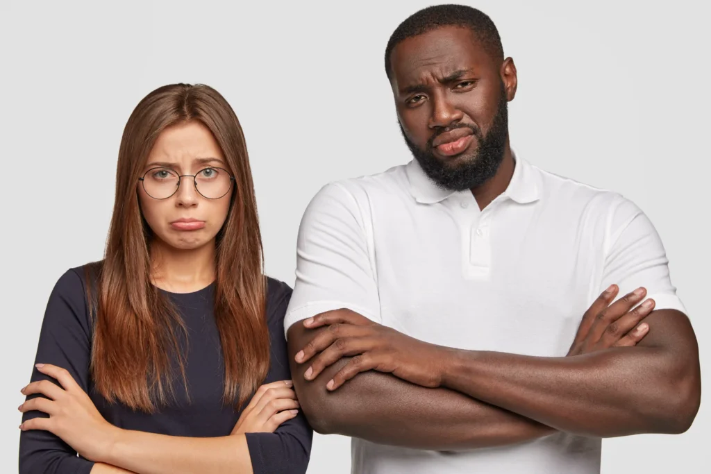 Partner crossing arms during conflict, representing defensiveness and emotional shutdown.